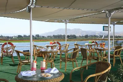 a row of tables and chairs with a view of the water at Iberotel Amara Nile Cruise - Every Thursday from Luxor for 07 & 04 Nights - Every Monday From Aswan for 03 Nights in Luxor