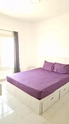 a bed with purple sheets in a white room at La bonita one bedroom apartment in Hurghada