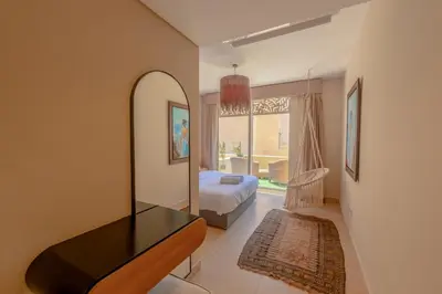 a bedroom with a bed and a table and a mirror at Fresh & Modern 1BR in El Gouna. Mangroovy Pool & Beach in Hurghada