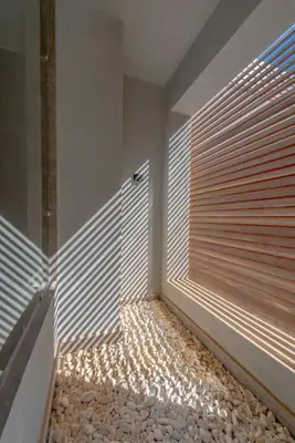 a room with wooden blinds on a wall with rocks at Modern & Comfy 2BR in Bali, El Gouna. Private Patio & Pool in Hurghada