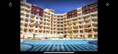 a large apartment building with a large swimming pool at Benashti Hurghada apartment in Hurghada