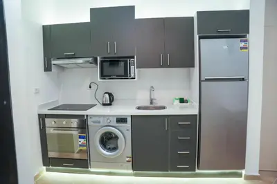 a kitchen with a washing machine and a refrigerator at Benashti Hurghada apartment in Hurghada