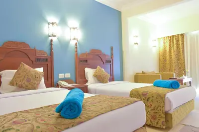 a hotel room with two beds and blue walls at Jasmine Palace Resort in Hurghada