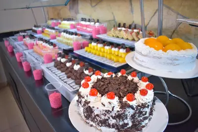 a display of cakes and other desserts on a table at Jasmine Palace Resort in Hurghada