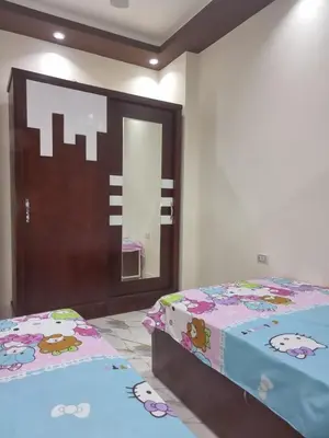 a bedroom with two beds and a mirror at Coral House in Hurghada
