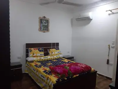 a bedroom with a bed with colorful sheets and pillows at Coral House in Hurghada