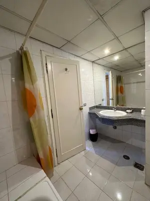 a bathroom with a shower and a sink and a door at Queens Valley Hotel in Luxor