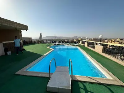 a swimming pool on the roof of a building at Queens Valley Hotel in Luxor