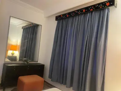 a room with a curtain and a chair and a mirror at Entertainment Central Location in Hurghada