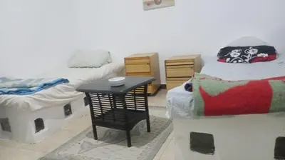 a room with two twin beds and a small table at Entertainment Central Location in Hurghada