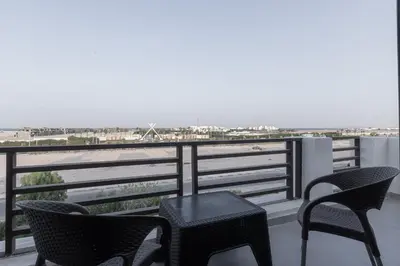 a balcony with chairs and a table and a view of the ocean at SOLA INN Hotel Hurghada in Hurghada