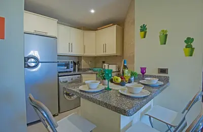 a kitchen with a table and chairs and a refrigerator at Buki-Gravity-Homes, Ap No2, seaview , HEATED pool, 5 star resort Gravity Sahl Hasheesh-FOR GUESTS WITH NONEGYPTIAN PASSPORTS in Hurghada