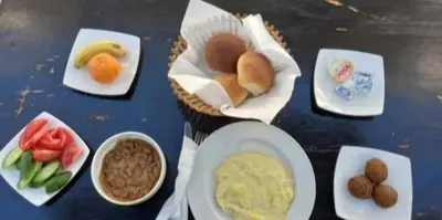 a table topped with plates of food and bowls of dips at West Bank Guest House in Luxor