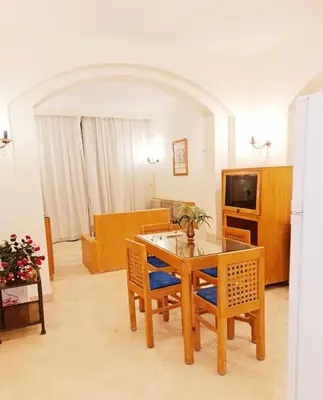 a living room with a dining room table and chairs at West golf 2bedroom in Hurghada