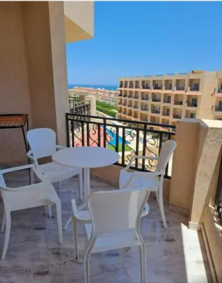 a balcony with white tables and chairs and a view at SELENA BAY RESORT WITH PRIVATE BEACH,SEA VIEw in Hurghada
