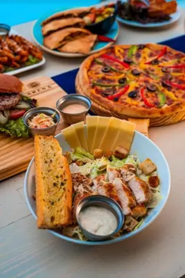 a table with a plate of food and a pizza at SELENA BAY RESORT WITH PRIVATE BEACH,SEA VIEw in Hurghada