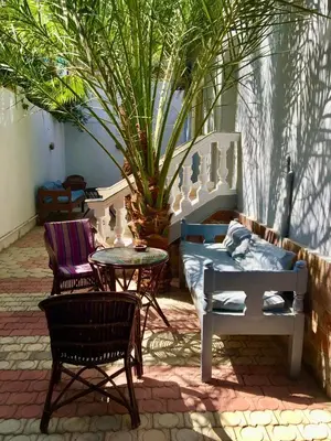 a patio with chairs and a table and a couch at Villa Elkoumy Apartments in Luxor