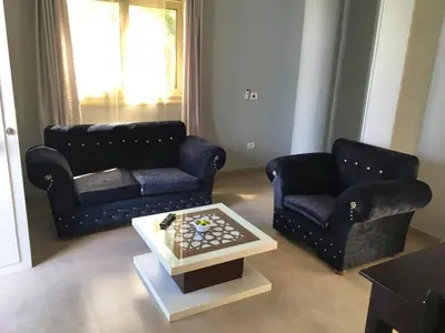 a living room with two couches and a coffee table at Villa Elkoumy Apartments in Luxor