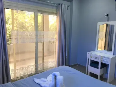 a bedroom with a bed and a mirror and a window at Villa Elkoumy Apartments in Luxor
