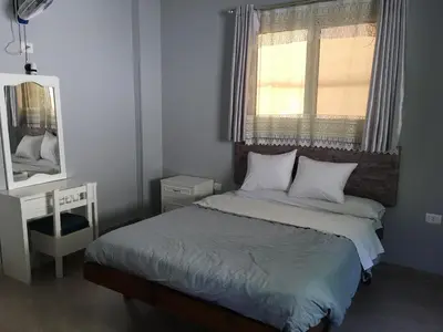 a bedroom with a bed with a window and a mirror at Villa Elkoumy Apartments in Luxor