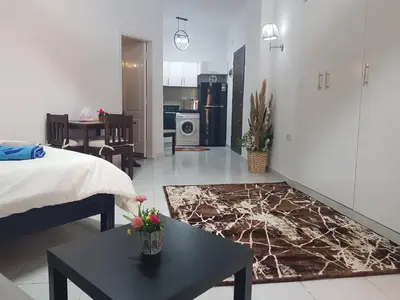 a room with a bed and a table and a kitchen at استديو هادي بوسط المدينه in Hurghada