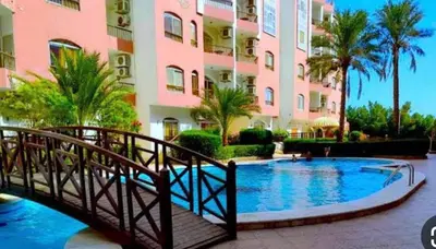 a bridge over a swimming pool in front of a building at استديو هادي بوسط المدينه in Hurghada