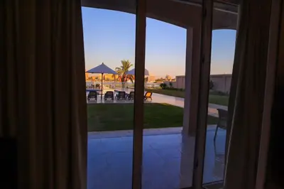 an open sliding glass door with a view of a patio at Royal Nile Villa - Nile View Apartment 1 in Luxor