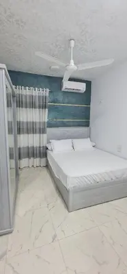 a bedroom with a bed and a blue and white wall at Nuba Heart in Aswan