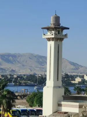 a lighthouse on top of a building next to a body of water at happy home in Luxor