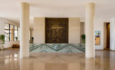 a lobby with two columns and a fountain in the middle at JAZ Elite Amara in Marsa Alam City
