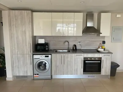 a kitchen with a sink and a washing machine at Mangroovy- Sensational 1BR Sea & Kite view in Hurghada