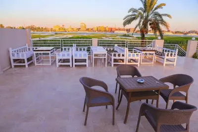 a group of tables and chairs on a patio at Royal Nile Villa - Luxury Nile View Apartment 1 in Luxor