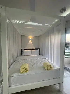 a white bed with two pillows on top of it at Royal Nile Villa - Luxury Nile View Apartment 1 in Luxor