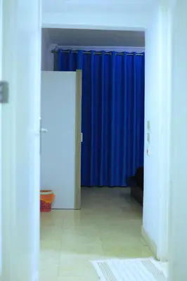 an empty room with blue curtains and a room with a floor at New Marina Hurghada Suite in Hurghada