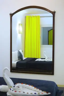 a mirror in a room with a bed and a bed sqor at New Marina Hurghada Suite in Hurghada