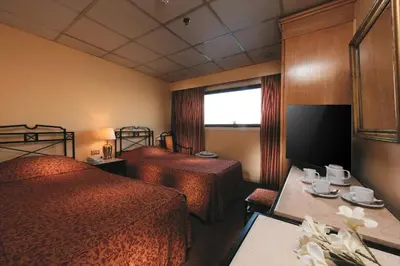 a hotel room with two beds and a table at Iberotel Helio Nile Cruise - Every Monday from Luxor for 07 & 04 Nights - Every Friday From Aswan for 03 Nights in Luxor