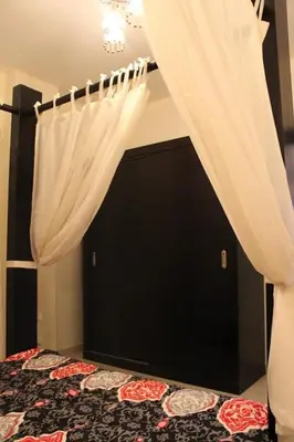 a bedroom with a bed with curtains and a tv at Baron palace 41 in Hurghada