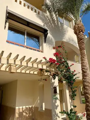 a white house with a palm tree in front of it at Apartment in el karma aqua beach resort hurghada near El gouna in Hurghada
