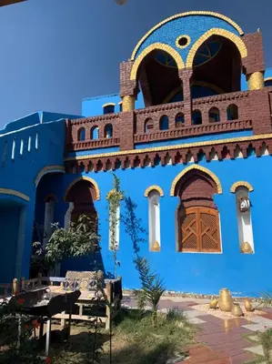 a blue building with windows and a bench in front at Golden Palace Family in Luxor