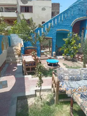 a patio with a blue building with a table and chairs at Golden Palace Family in Luxor