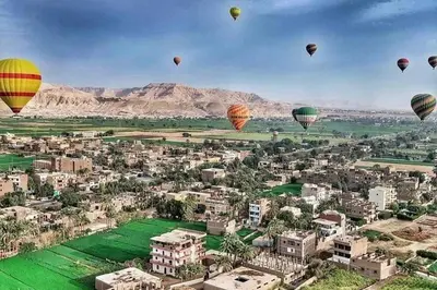 a group of hot air balloons flying over a city at Golden Palace Family in Luxor