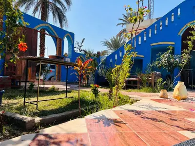 a blue building with a table and some plants at Golden Palace Family in Luxor
