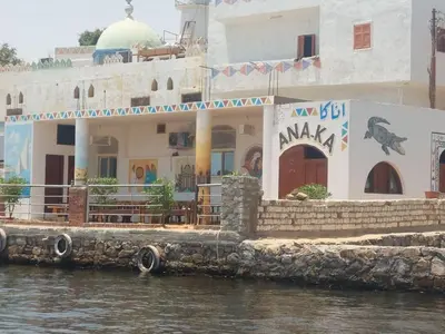 a building on the water next to a river at ANA-KA Guest house in Aswan