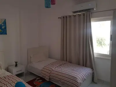 a small bedroom with a bed and a window at شقه جديده بالكامل في قلب الغردقه in Hurghada