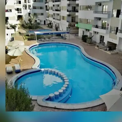 a large swimming pool in front of some apartment buildings at شقه جديده بالكامل في قلب الغردقه in Hurghada