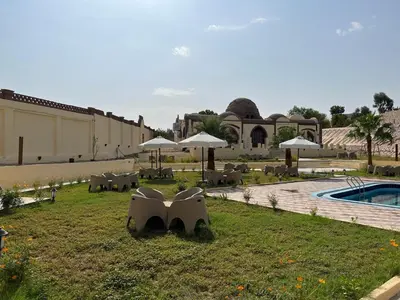 a resort yard with tables and chairs and a pool at Elphardous Oasis Hotel in Luxor