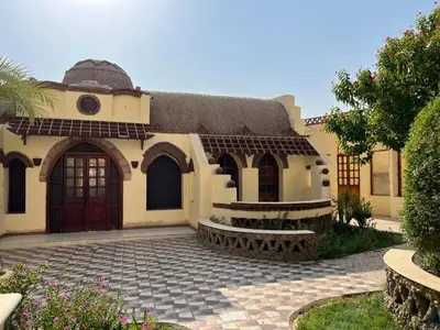 a house with a thatched roof and a driveway at Elphardous Oasis Hotel in Luxor