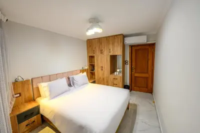 a bedroom with a white bed and a wooden door at Rhapsody of Luxor in Luxor