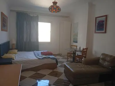 a bedroom with a bed and a couch and a table at Charming Marina Crib Pool Beach Gym Spa in Hurghada