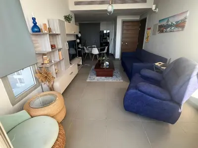 a living room with a blue couch and a table at 1BR with private Heated Jacuzzi at Sholan Elgouna in Hurghada